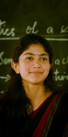 a woman standing in front of a chalkboard with writing on it's side