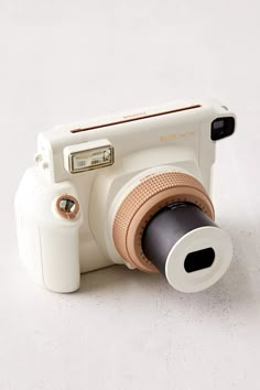 a white camera sitting on top of a table next to a black and brown object