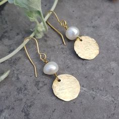 This collection of golden, artisan earrings is made from solid brass and freshwater pearls in beautiful Cornwall. The brass is hand beaten on a weathered, antique anvil, giving a unique and shimmering texture.  This range is inspired by the textures of ancient jewellery, paired with graphic, contemporary shapes. The look is bold and warm, reflecting the Summer sun or bringing a golden glow to grey days. Beaten gold and freshwater pearl was a combination much favoured in Ancient Rome, and it rema Brass Pearl Earrings As A Gift, Handmade Brass Pearl Earrings As Gift, Delicate Handmade Brass Earrings, Elegant Brass Pearl Earrings, Bohemian Brass Pearl Drop Earrings, Ancient Jewellery, Rome Antique, Handmade Jewlery, Pearls Diy