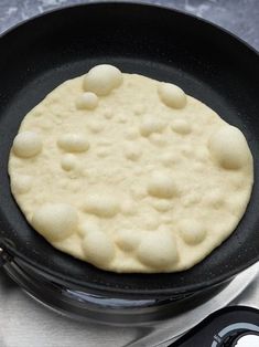 a skillet with some food in it on top of a table next to a remote control