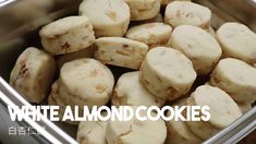 there is a metal bowl full of white almond cookies on the table and text overlay reads, white almond cookies