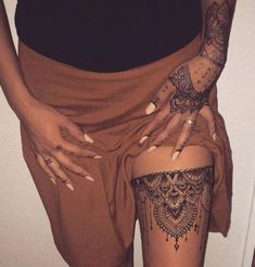 a woman with tattoos on her thigh and leg