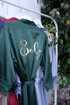 robes are hung on a rack with the name bely