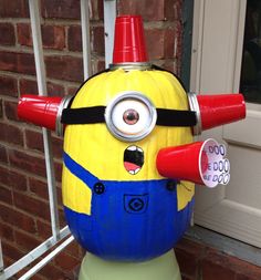 a yellow and blue toy with horns on it's head sitting in front of a brick building