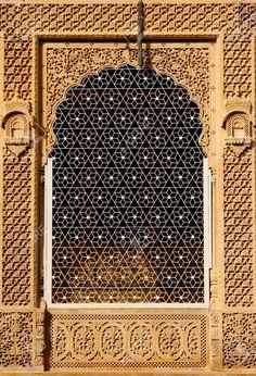 an intricately designed window in the middle of a building with arabic writing on it