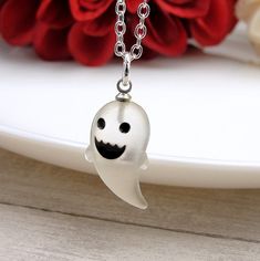 "This Ghost Charm necklace comes on a silver-plated chain that is available in different lengths. Please choose your desired length from the drop-down menu when placing the item in your shopping cart. { CHARM DETAILS } ★ Material: Resin ★ Finish Color: White ★ Measurements: 3/8\" x 3/4\" ★ Dimensions: 3-Dimensional { SIMILAR ITEMS } More Halloween themed items available from my shop: https://www.etsy.com/shop/treasuredcharms/search?search_query=halloween { GIFT OPTIONS} Gift boxes are available at no additional cost and can be added from the drop-down menu during checkout.   You can mark it as a gift, add a gift message, and send it directly to a recipient by entering their address in the 'shipping address' during checkout.  Receipts with price information are not included with orders that White Jewelry Gift, White Necklace For Halloween Gift, White Halloween Necklace Gift, Themed Personalized Jewelry For Halloween, White Gothic Necklace Gift, Personalized Themed Jewelry For Halloween, Fun White Halloween Jewelry, Halloween Themed Personalized Jewelry, Spooky White Halloween Jewelry