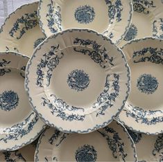 a bunch of blue and white plates stacked on top of each other