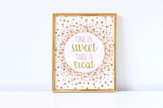 a white wall with a gold frame that says one on it and polka dots in the background