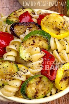 pasta with roasted veggies and sauce in a white bowl on a wooden table