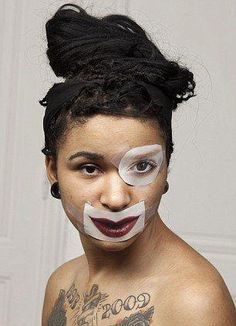 a woman with her face painted like a clown and nose tape around her eyes,