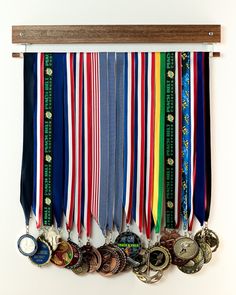 several medals are hanging on a wall with a wooden hanger in front of them