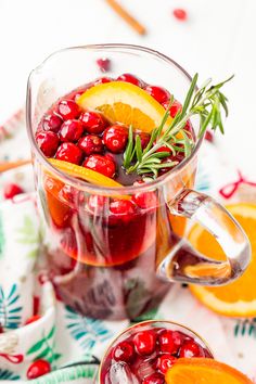 a pitcher filled with cranberries and oranges