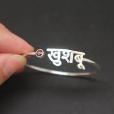 Personalized Hindu Name Bracelet is handmade with its own uniqueness. It can be bought as a gift for any occasion like birthday gift, wedding gift, travel gift, souvenir and etc. If you need rose gold plating or yellow gold plating, please contact us, we will advice you on the additional fees applicable.Base Material: Sterling Silver Size: 11mm (Approximately)Bangle wrist size: 7'' - 8'' Inches. Adjustable / Please give us your wrist circumference.Stone: Red CZ setting (Default) Or check with us Meaningful Silver Name Bracelet As Gift, Personalized Red Jewelry For Birthday Gift, Sterling Silver Name Bracelet Gift, Personalized Spiritual Red Bracelets, Red Personalized Spiritual Bracelets, Personalized Red Spiritual Bracelets, Custom Name Bangle Jewelry As Gift, Customized Bangle Name Bracelet As Gift, Custom Name Bangle As Gift