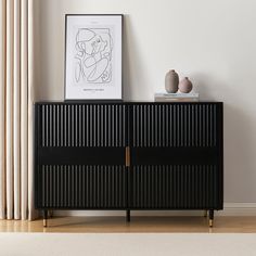 a black cabinet sitting on top of a hard wood floor next to a white wall