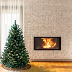 a small christmas tree in front of a fireplace