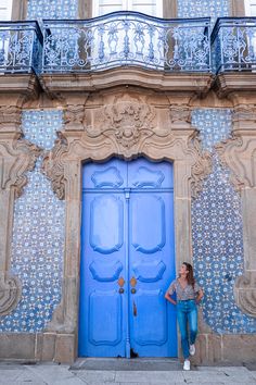 a woman standing in front of a blue door