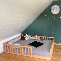 a child's room with green walls and wooden flooring, including a crib