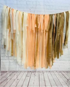 an orange and yellow streamer hanging from a white brick wall next to a wooden floor