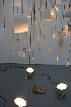 several lights are hanging from the ceiling in a room with gray flooring and white walls