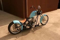 a blue and black motorcycle parked in front of a building