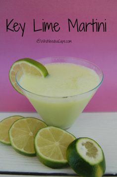 a glass filled with limeade next to sliced limes