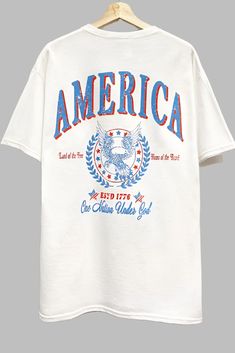 America Graphic T Shirt Retro American Flag Print Summer T-shirt, Americana Cotton T-shirt With Letter Print, Independence Day American Flag T-shirt, 4th Of July Streetwear T-shirt With Letter Print, 4th Of July Cotton T-shirt With Text Print, White Americana Letter Print T-shirt, American Style Flag Print T-shirt For 4th Of July, White Flag Print T-shirt For Streetwear, Patriotic Graphic Print T-shirt For Summer