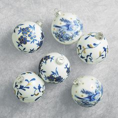 six blue and white ornaments on a gray surface