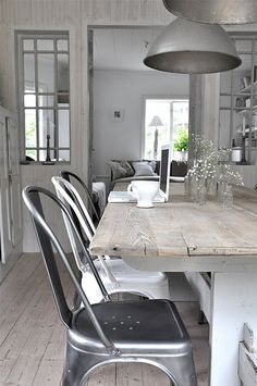 a dining room table with chairs and a lamp hanging over it's head in the center