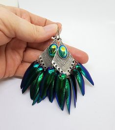 These earrings are Stunning! Matte silver metal connectors accented with gorgeous vintage cabochons that I accented with Exotic genuine beetle wings. Each earring has 9 beetle wings. The wings are stunning shades of emerald green and indigo, with incredible shine in person! These earrings are approx. 3.5 inches long including the stainless steel lever back closures.   These are Elytra Sternocera beetle wings from Thailand. The insects are farmed in accordance with the regulations of CITES, (Conv Pastel Goth Earrings, Oddities Jewelry, Insect Necklace, Green Beetle, Beetle Wings, Porcelain Necklace, Goth Earrings, Cat Pendant Necklace, Wing Jewelry