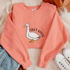 "Comfort Colors brand Silly Goose Sweatshirt, Funny Best Friends gift for Birthday, Silly goose sweatshirt for men or women, Holiday Gift for Goose Lover, goose sweatshirt, silly goose gift, farm animal shirt in pastel colors. All sweatshirts and Hoodies are UNISEX.   Due to the nature of this product I am unable to accept returns or exchanges.  All items are made to order once order is placed.  Please make sure your order is accurate before placing order. SHIPPING AND PROCESSING TIMES  We provide flat-rate shipping, ensuring consistent shipping costs, regardless of the number of shirts you order! Refer to below turnaround times. US ORDERS: \"Standard\" shipping delivers within 2 weeks* from the order date. \"Rush\" shipping arrives within 1 week* from the order date. *Please note that hol Silly Goose Shirt, Silly Duck, Friends Sweater, Funny Best Friend Gifts, Goose Sweatshirt, Silly Goose, Pet Shirts, Star Work, Farm Animal