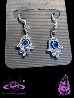 Wear your protection with these cute hamsa hand evil eye earrings. Bohemian Evil Eye Earrings As Gift, Spiritual Evil Eye Dangle Jewelry, Handmade Dangle Jewelry For Good Luck, Metal Dangle Earrings With Evil Eye, Symbolic Evil Eye Jewelry For Festival, Sterling Silver Evil Eye Dangle Earrings, Bohemian Evil Eye Dangle Jewelry, Spiritual Sterling Silver Earrings For Festivals, Spiritual Dangle Plug Earrings As Gift