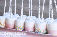 marshmallows are lined up on a tray with toothpicks in them