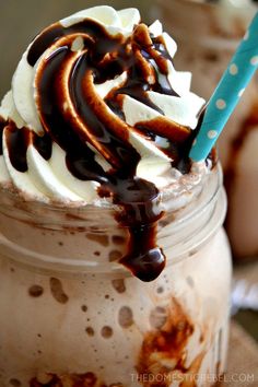 there is a chocolate milkshake with whipped cream and chocolate drizzle on top