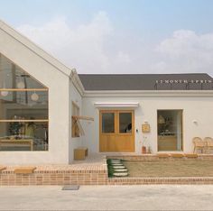 a small white building with some chairs outside