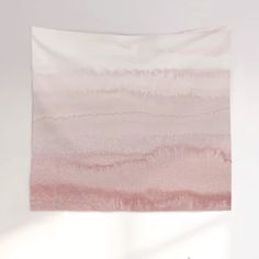 a pink and white wall hanging over a bed