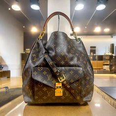 Louis Vuitton Monogram Metis Hobo 100% Guaranteed Authentic Plus Adjustable Shoulder Strap The Louis Vuitton Mtis Hobo Is A Sophisticated Blend Of Timeless Elegance And Modern Functionality. Crafted From The Brand's Signature Brown Water Resistant Lv Signature Monogram Canvas, This Luxurious Handbag Features A Supple, Relaxed Silhouette That Gracefully Drapes Over The Shoulder. The Polished Golden Hardware, Including The Iconic Lv Push Lock Front Hardware On The Front Pocket And Adjustable Leather Strap, Adds A Touch Of Refinement. Inside, A Well-Organized Interior With Multiple Compartments Ensures Practicality, Making The Mtis Hobo A Perfect Companion For Everyday Use. It Is Spac Lv Metis, Louis Vuitton Metis, Brown Water, Great Body, Canvas Shoulder Bag, Monogram Canvas, Leather Handle, Louis Vuitton Monogram, Front Pocket