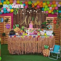 an aloha themed birthday party with pineapples, flowers and balloons on the wall