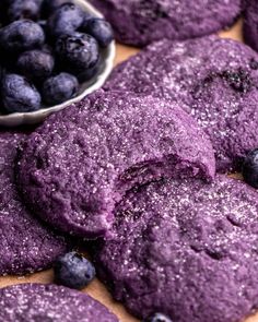 blueberry cookies with powdered sugar on top and bowl of blueberries in the background