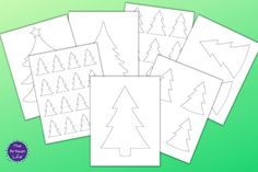 five christmas trees cut out from paper on a green background