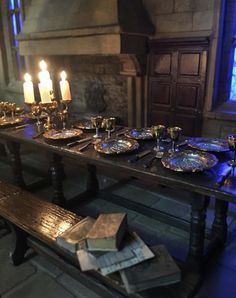 a long table with plates and candles on it