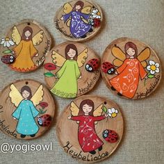 four wooden magnets decorated with angels and ladybug's on the back