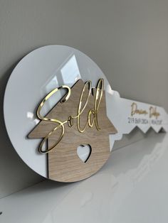 a wooden christmas ornament with the word sale on it and a heart cutout