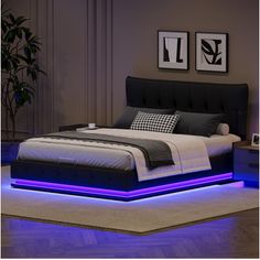 a bed with blue lights underneath it and a black headboard on top of the bed