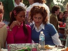 two women sitting at a table in front of a cake