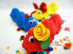 three colorful stuffed animals on top of a white surface with confetti scattered around them