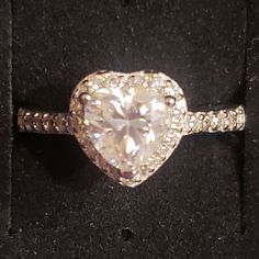 a heart shaped diamond ring sitting on top of a black box