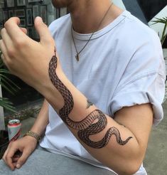 a man with a snake tattoo on his arm