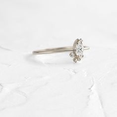 6x3mm marquise cut white diamond focal (SI1 clarity, G+ color) Three SI clarity white accent diamonds (1-2mm) Solid 14k gold setting with a delicate 1.2mm tapered round band (available in yellow, rose, and white) Total carat weight: .28ct. We handcraft each piece with responsibly sourced 14k gold and ethically sourced stones. Oval Diamond Stackable Promise Rings, Diamond White Marquise Cut Diamond Ring Gift, Delicate Sterling Silver Ring With Single Cut Diamonds, Gift Diamond Ring With Marquise Cut, White Gold Cluster Ring With Diamond Cut Lab-grown Diamond, White Platinum Diamond Ring With Rose Cut, White Cluster Ring With Diamond Cut Lab Grown Diamonds, Timeless Marquise Sterling Silver Ring, Marquise Diamond White Diamond Ring As Gift