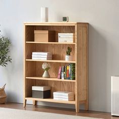 a wooden book shelf with books on it next to a wall mounted air purificater