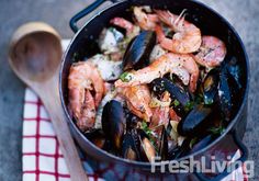 a pan filled with shrimp and mussels on top of a table